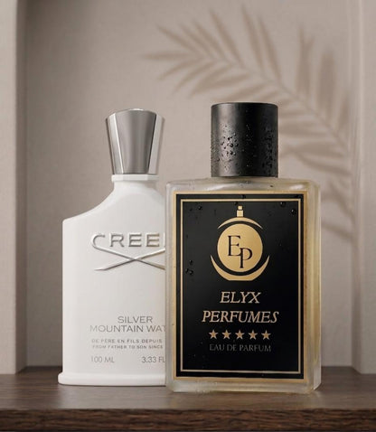 Two perfume bottles, one white and one black with gold accents, on a wooden surface.
